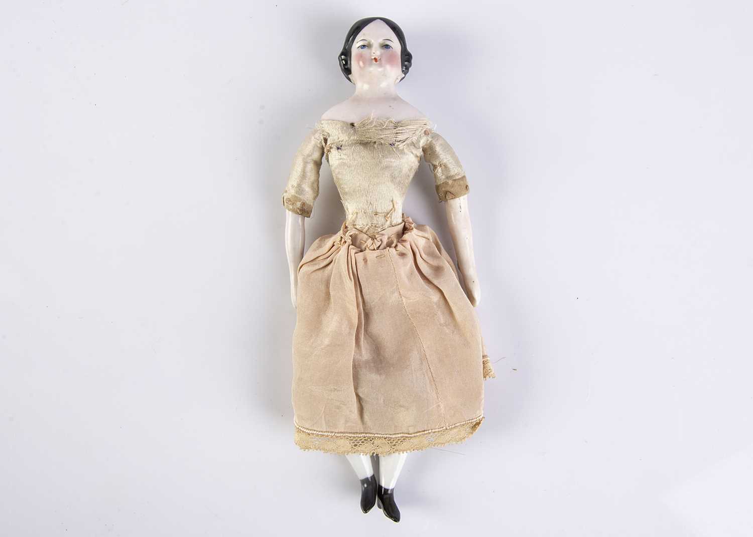A 19th century pink-tinted china shoulder head dolls’ house doll,