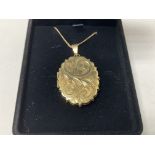 A 9ct gold engraved locket. Approx 9.9g.