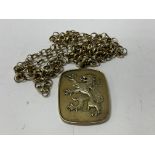 A heavy silver gilt rampant lion ingot and chain.