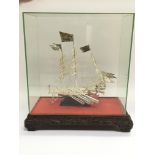 A white metal model of a Chinese junk in a present