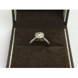 A 9ct white gold ring set with a central diamond,