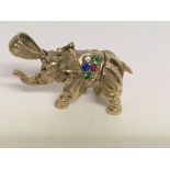 A 9 ct gold elephant pendant with gem stone inset