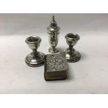 A pair of small silver candle sticks a silver pepp