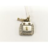 A 9ct gold diamond set pendant with key in the for