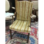 A late George III oak open arm chair. The shaped arms with scroll carved ends with later yellow