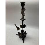 Unusual bronze candlestick supporting a small cher