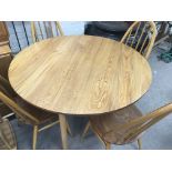 A circular Ercol dining table and four matching ch