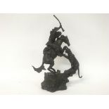 A bronze figure of a Indian on horse back with tig