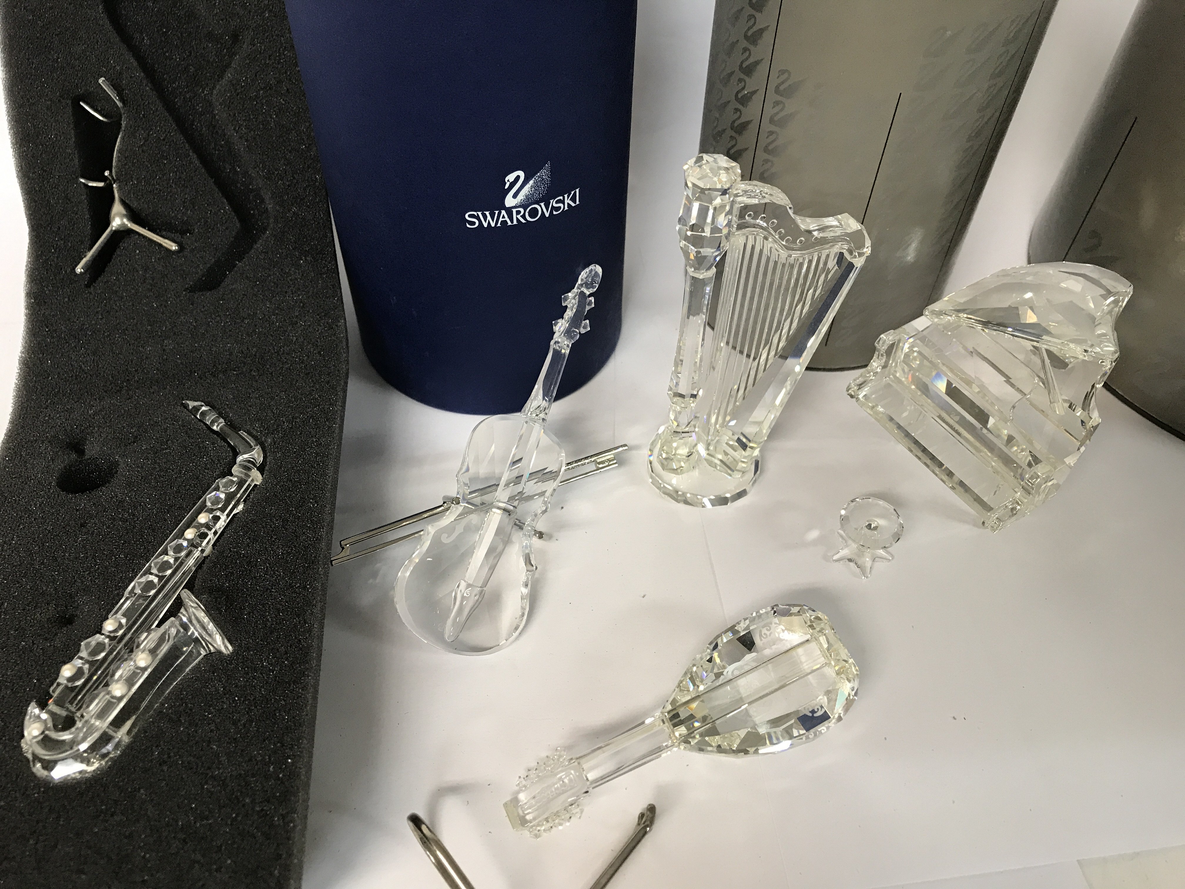 Five boxed Swarovski pieces including Violin, Saxophone, Grand Piano and Stool, Harp and Lute plus