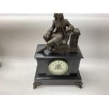 A slate mantle clock with classical figure on top.