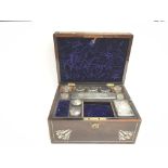 An antique travelling vanity box with silver plate