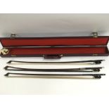 Three Cello bows in a case.