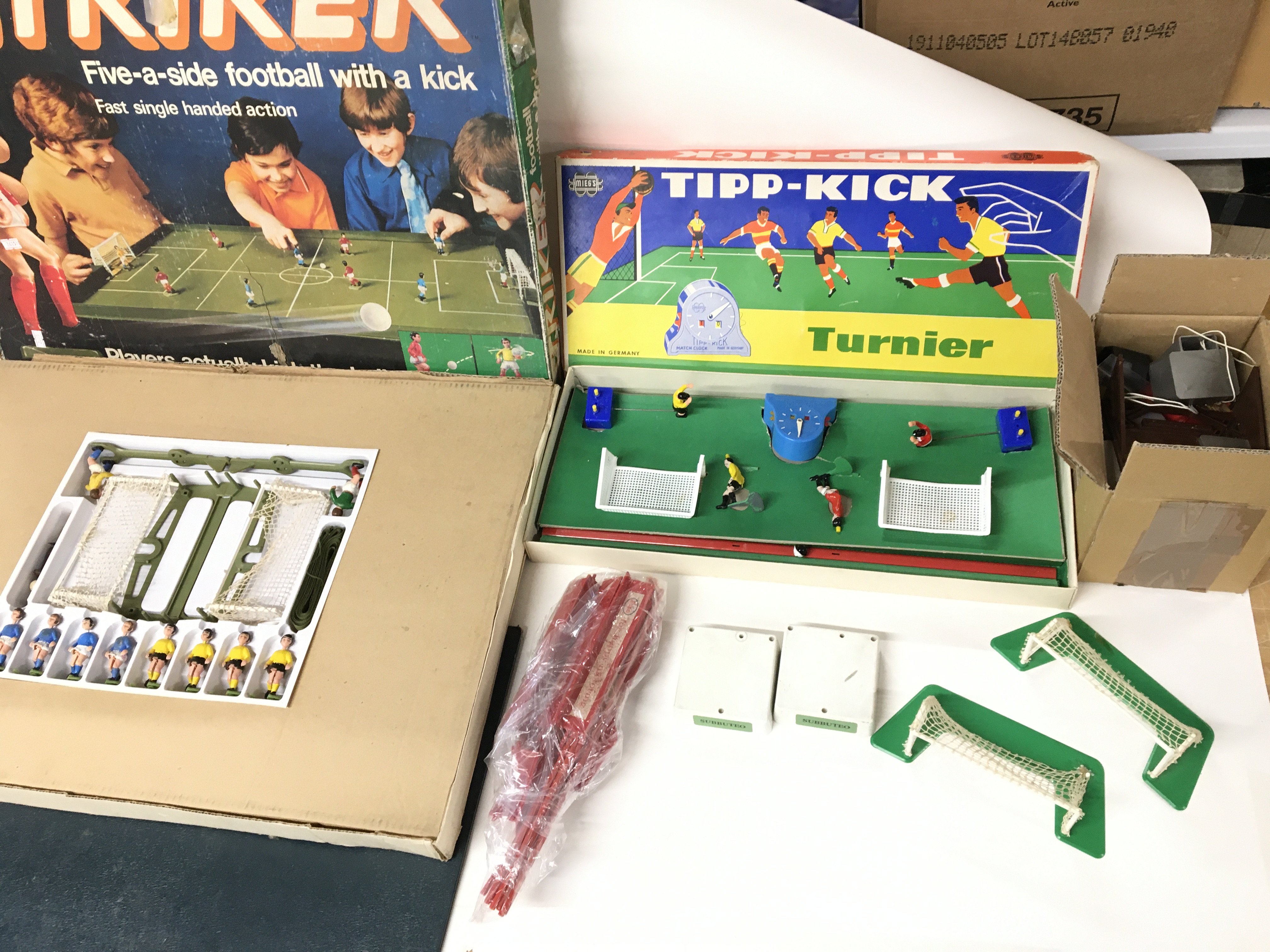 Two vintage table top football games and a box of various related accessories.