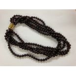 A multi string necklace if polished garnet beads m