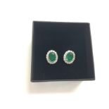 A boxed pair of 18ct white gold oval emerald and R