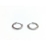 A pair of silver hoop earrings set with CZs, appro
