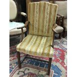 A late George III oak open arm chair. The shaped a