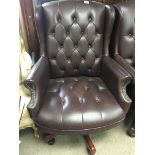 A modern leather upholstered revolving wing arm ch