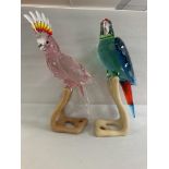 Two large Swarovski birds on wooden stands, in fit