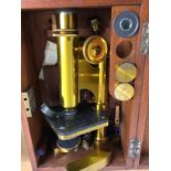 A brass microscope in a mahogany case .