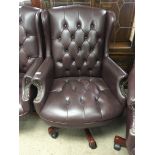 A conforming leather upholstered wing arm chair.