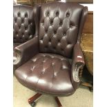 A leather upholstered revolving wing armchair.