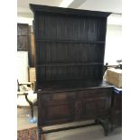 An oak dresser with a raised back above cupboards