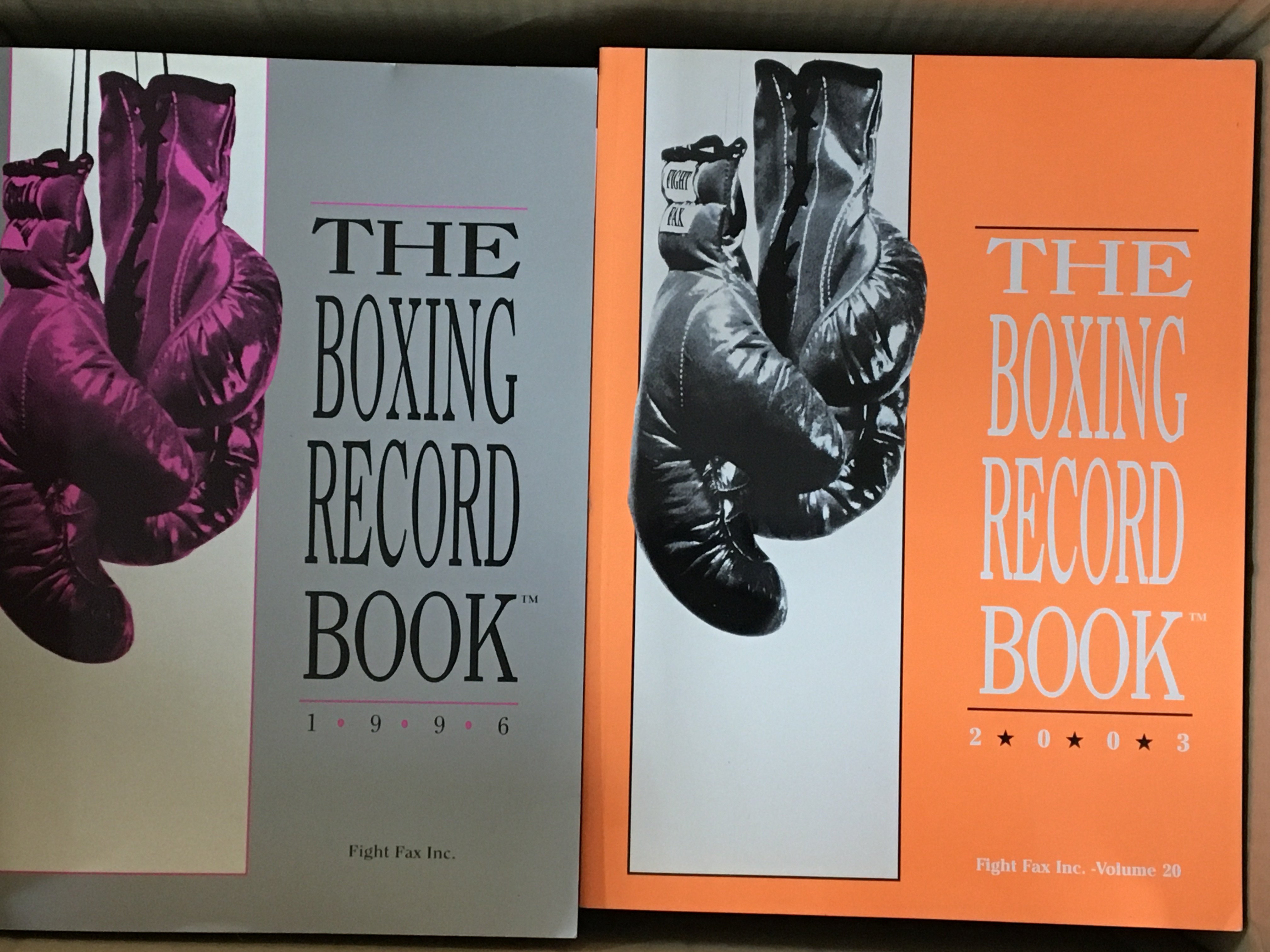 Two boxes containing boxing records The Boxing Record book annual issues.