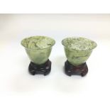 A par of jade cups on hardwood stands, total appro