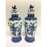 A pair of blue and white vases with covers having