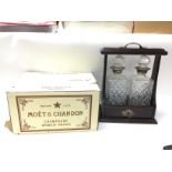 A box of unopened Moet champagne with a mahogany t