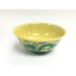 An Oriental bowl decorated with green dragons on a