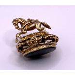 A 9ct gold fob in the form of a horse on a bridge