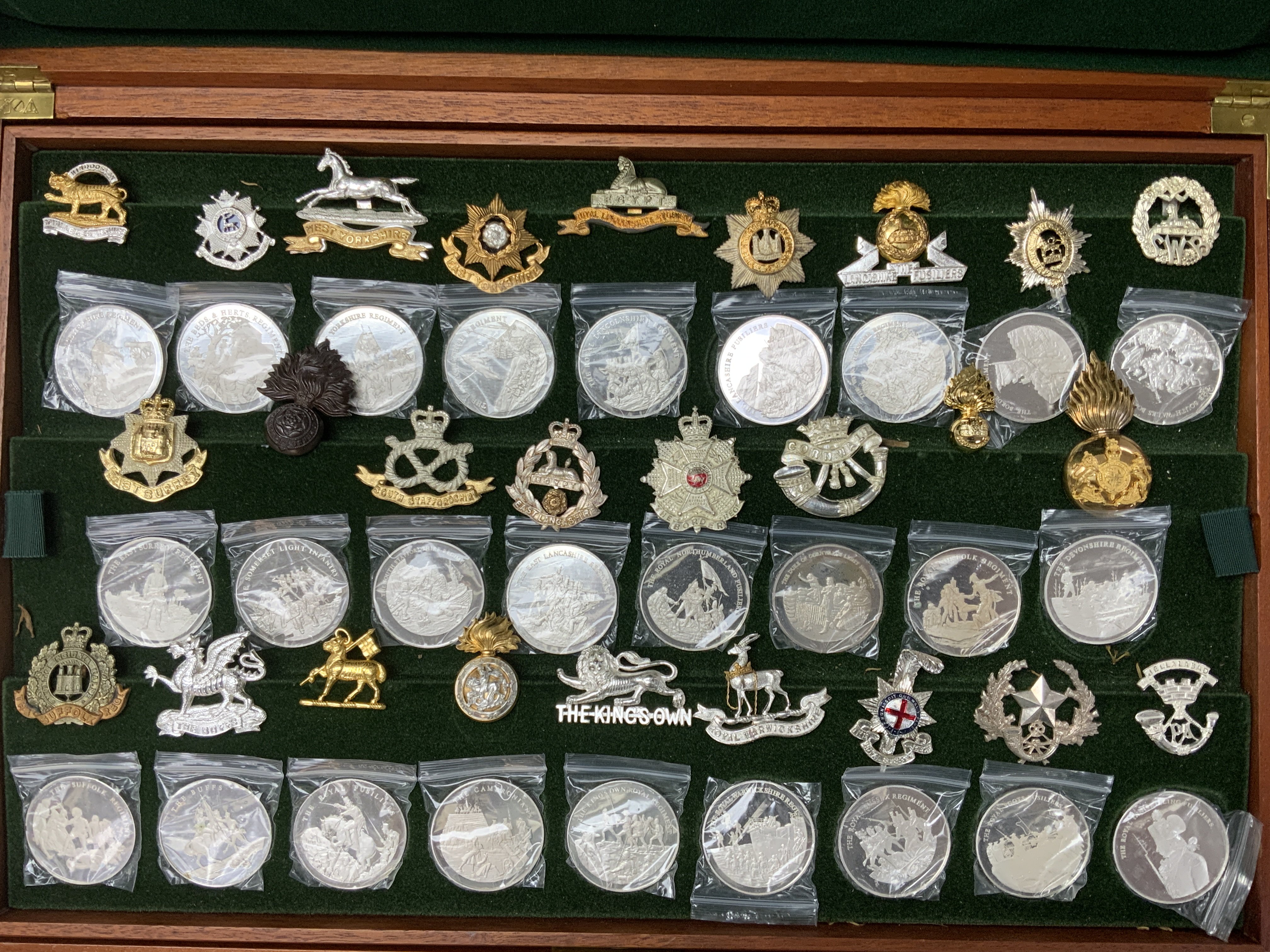 A full cased set of Regimental cap badges together