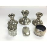 Three silver candlesticks, napkin ring, vesta case