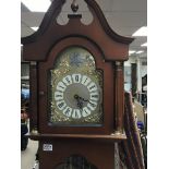 A reproduction Mahogany longcase clock with visible pendulum and weights