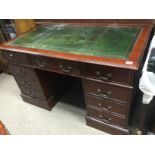 A reproduction mahogany desk, 137cm x 76cm x 81cm.