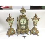 A clock garniture set in heavily swept gilt decoration and with transfer printed decorated panels.