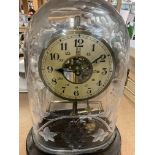 A Bulle electric mantle clock under a glass engraved dome .