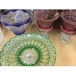 A collection of coloured cut glass including vases and fruit bowl .