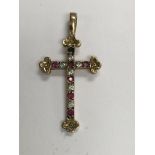 A 9 ct gold cross pendant with gem stones inset mi