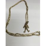 A 9 ct gold chain with attached clown pendant. Tot