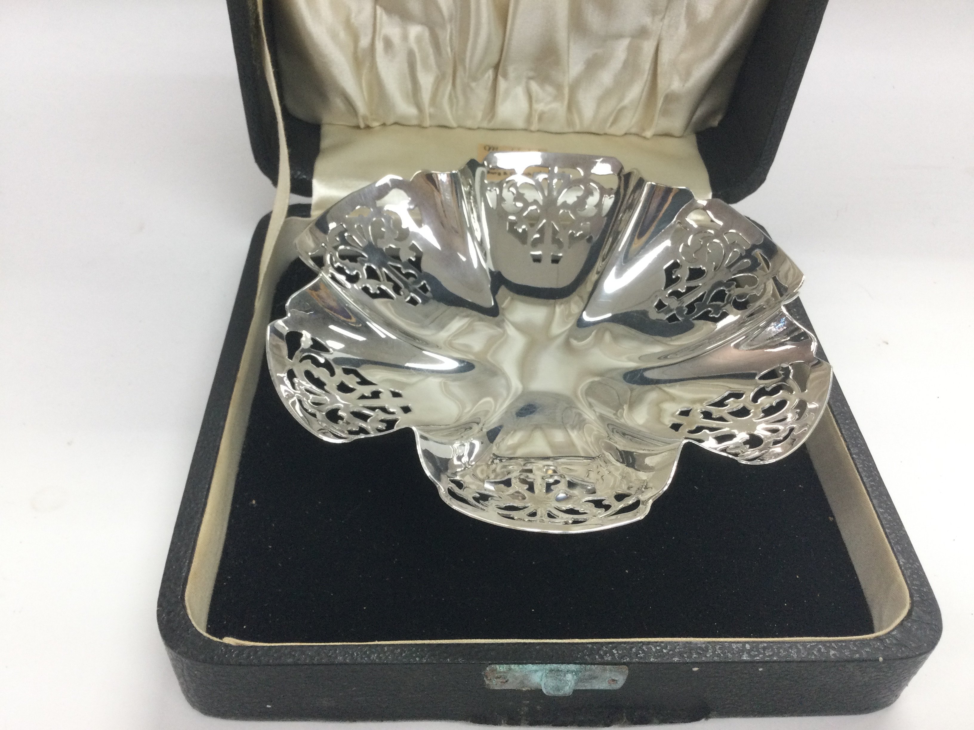 A cased silver bon bon dish with piercework decora