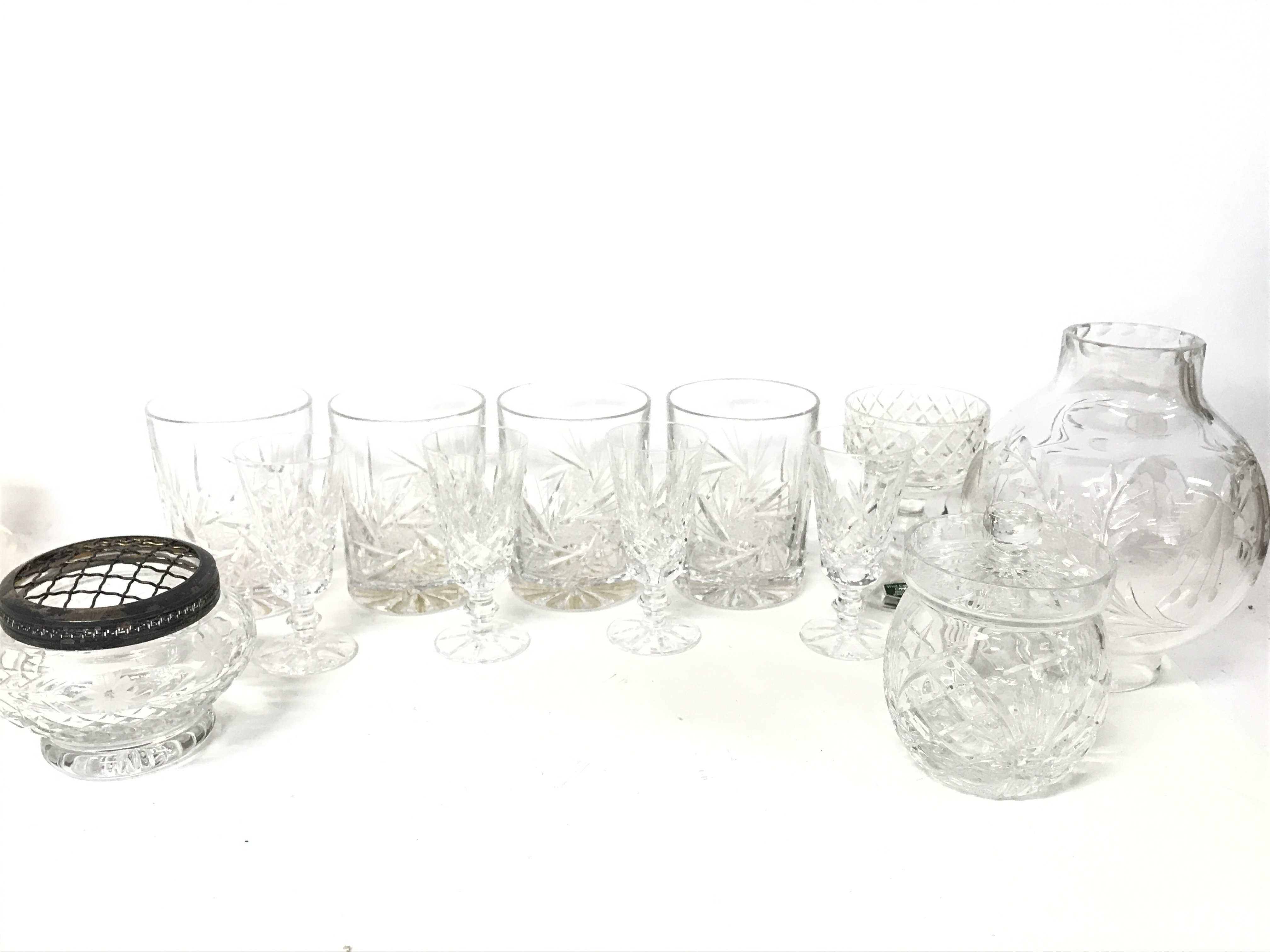 A set of cut glasses, a lidded glass jar, clear gl