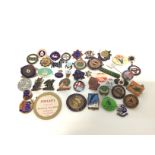 A collection of vintage pins and badges including