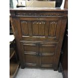 A walnut cocktail cabinet with linen fold panels f