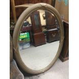 An oval wall mirror with bevelled edge, approx height 106cm. Shipping category D.