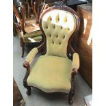 A Victorian mahogany open arm chair upholstered in