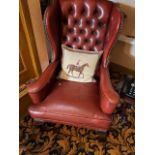 A red leather wing back arm chair on cabriole legs