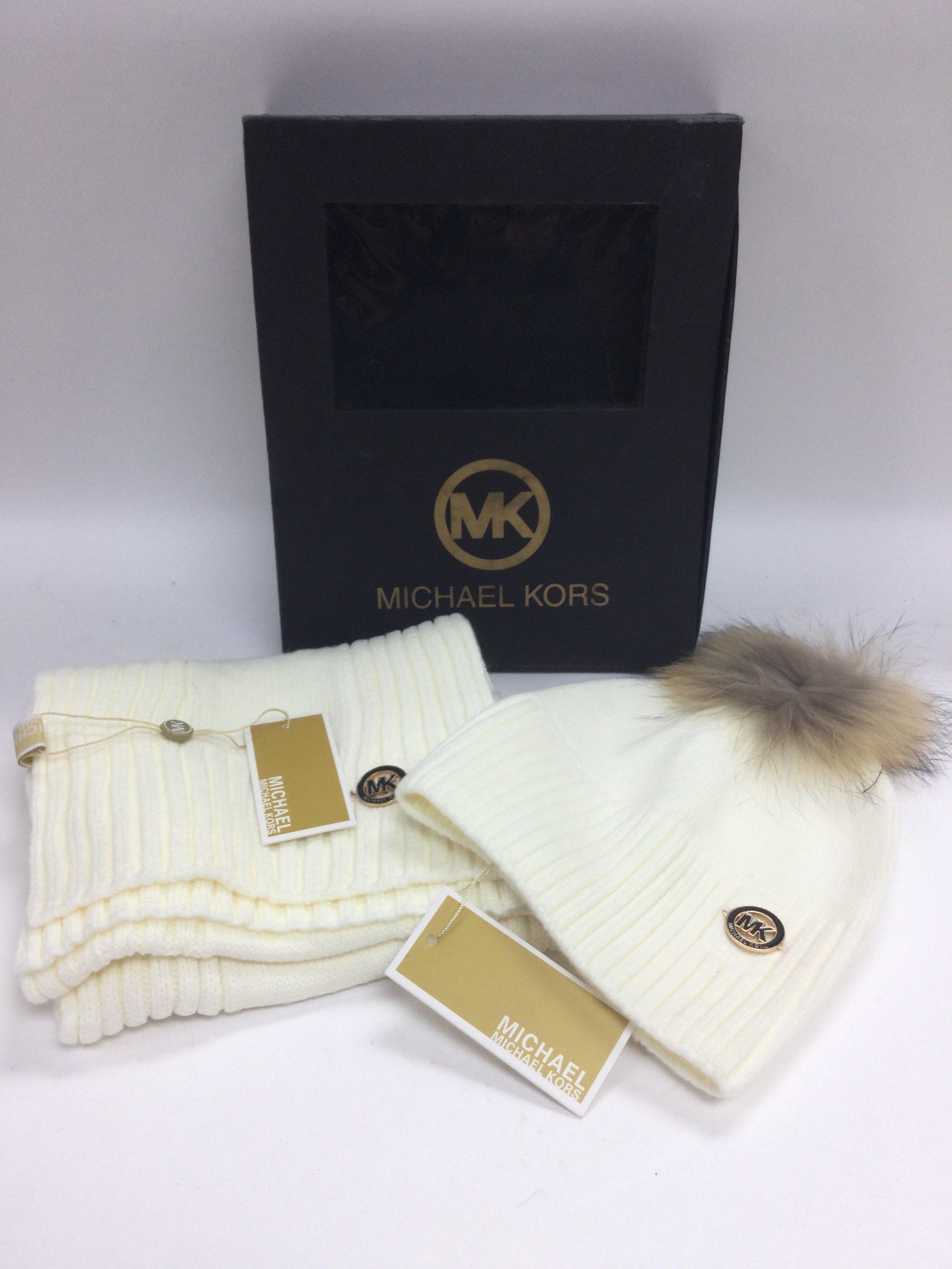 A boxed Michael Kors hat and scarf set. Shipping c